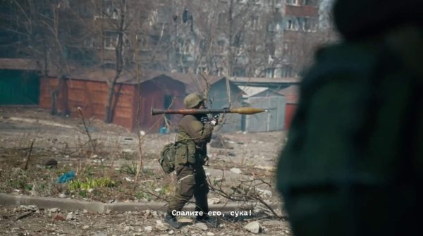 Російський військовий під час пересування житловими кварталами Маріуполя, імітуючи протистояння українським військовим, стріляє з протитанкового гранатомета поблизу  будинків на вул. Куїнджі, 144, 146 та 148. Кадр із фільму «У края бездны. Битва за Мариуполь глазами очевидца».