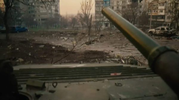 Кадр із фільму «У края бездны. Битва за Мариуполь глазами очевидца», відзнятий на камеру, встановлену на танк. Танк пересувається між будинками по вул. Куїнджі у сторону просп. Металургів та вул. Жовтневої. 